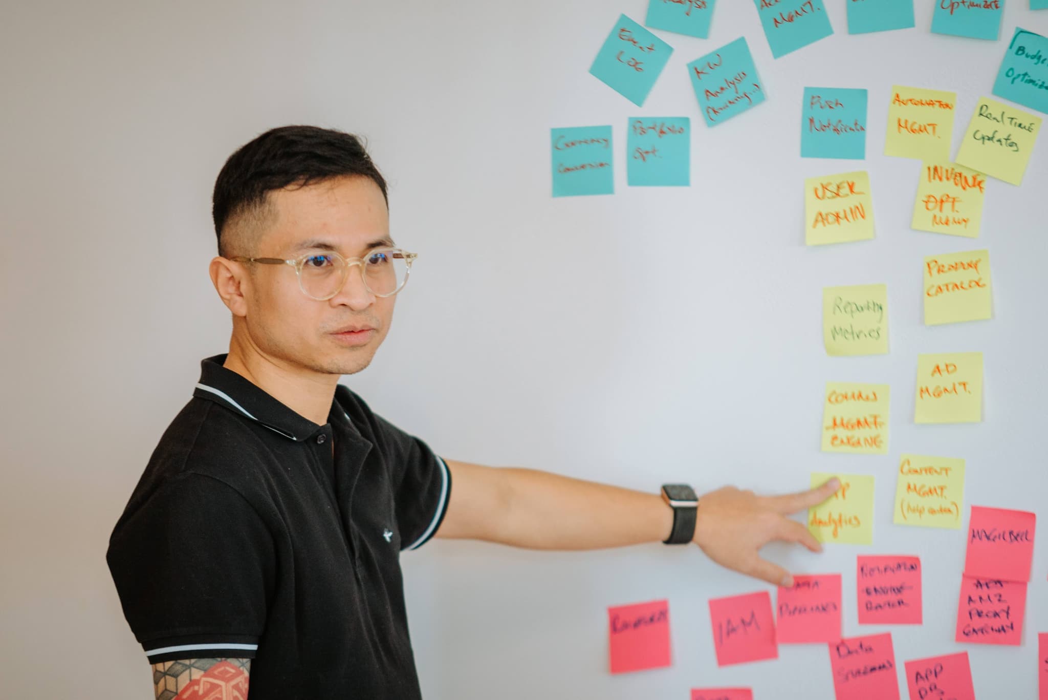 Henry pointing at sticky notes on a whiteboard